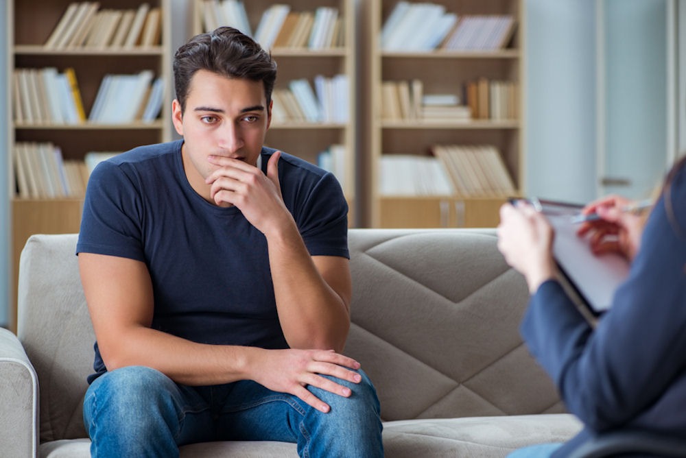a man suffering from alcohol addiction talking to his therapist