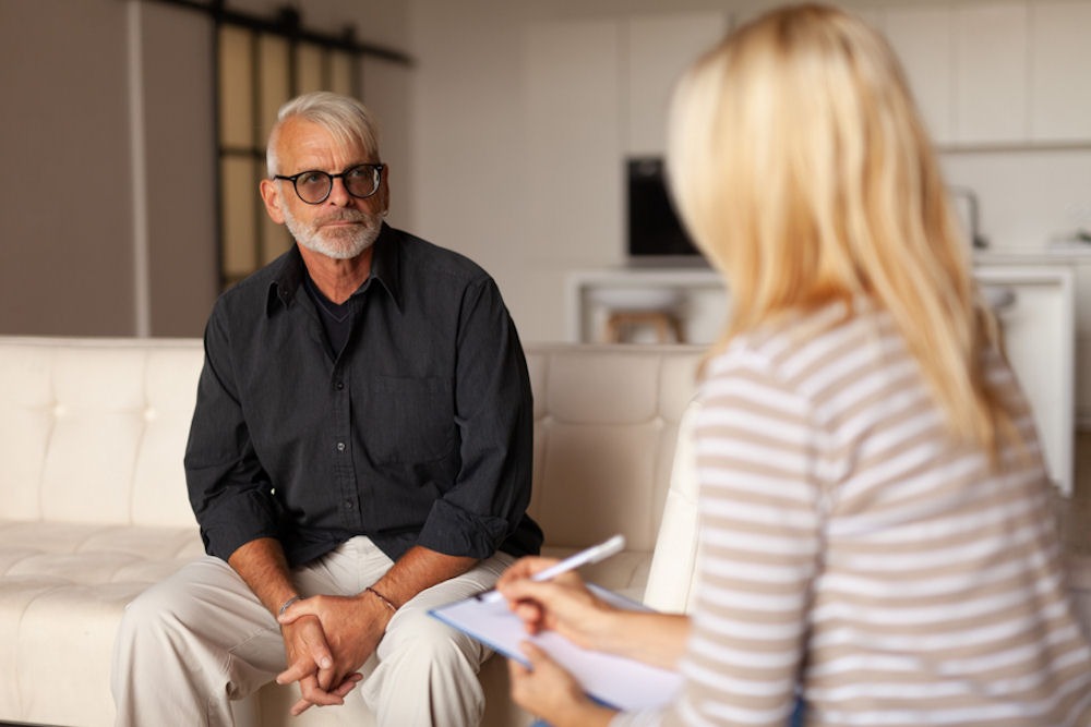 a senior talking to his therapist about signs of liver healing from alcohol